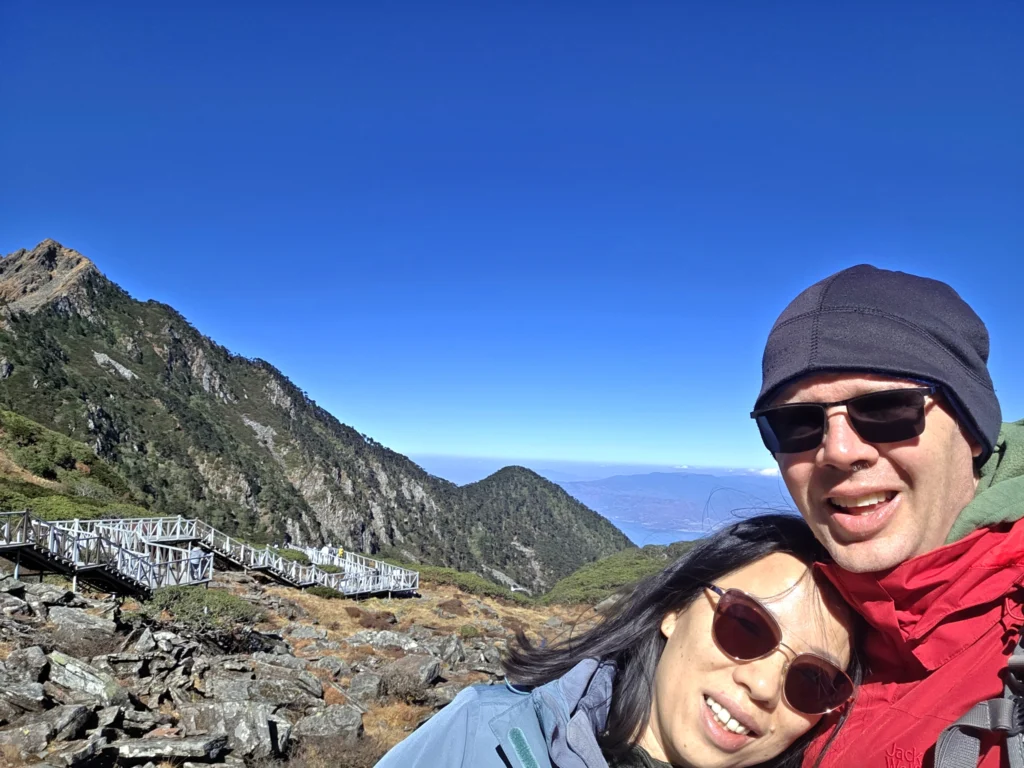 Rong und Stefan mit Blick auf das Gebirge hinter einem und dem Weg der zu dieser Plattform hoch führt.