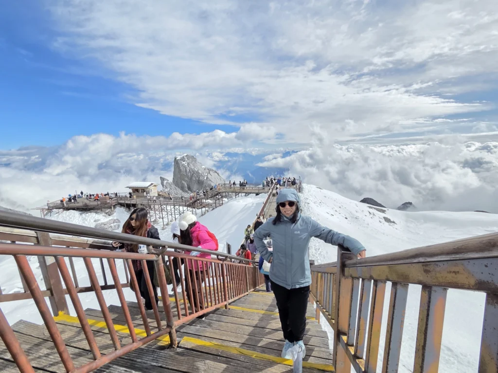 Rong mit Wolken, Schnee und Gebirge im Hintergrund auf einer Treppe