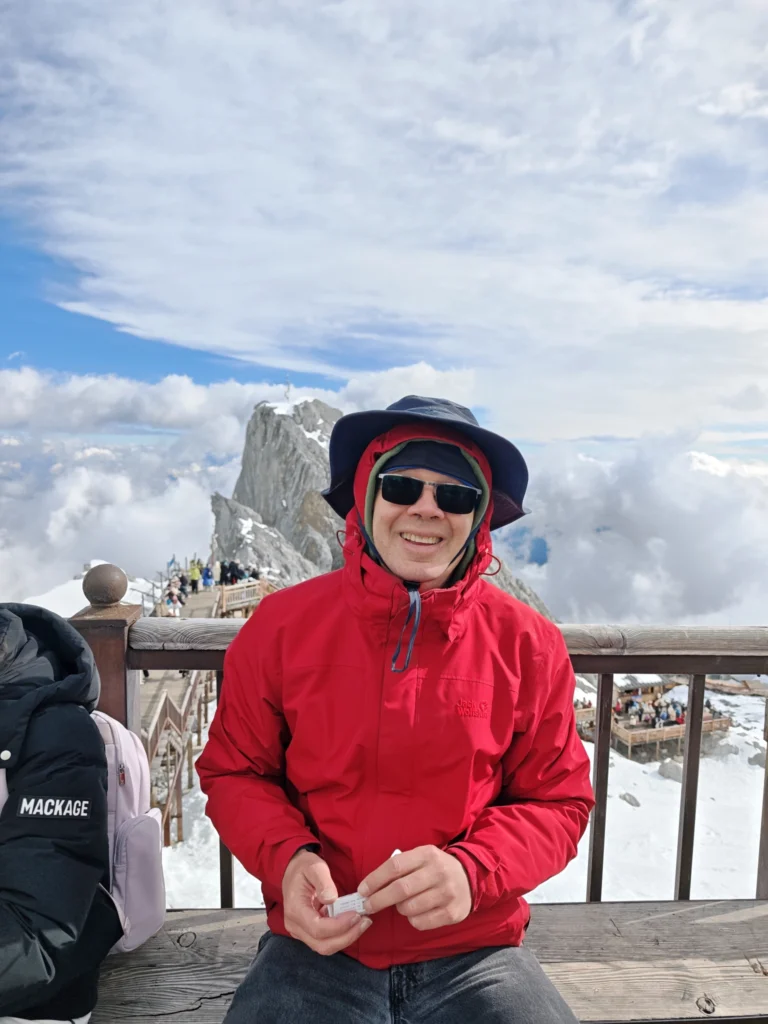 Stefan mit Gebirge im Hintergrund, er stärkt sich mit einem Ei
