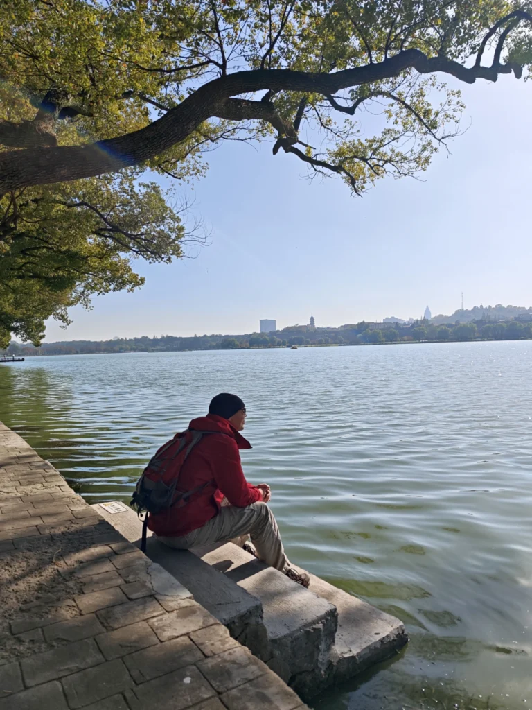 Stefan sitzt auf Treppen direkt am See